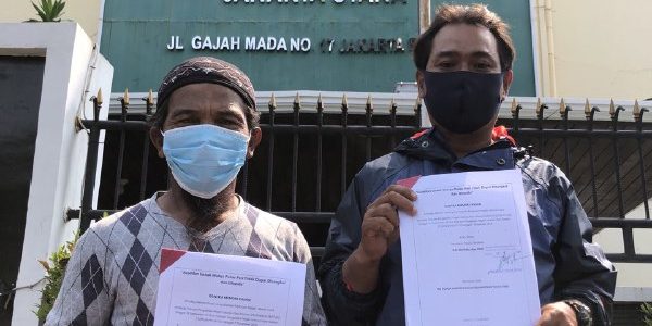 8813cb08-0422-418a-8a7f-1604845803ed Foto warga pulau pari memegang kertas gugatan di depan Pengadilan Negeri Jakarta Utara