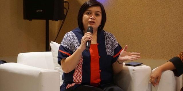 Atnike Nova Komisioner Komnas HAM, Atnike Nova sedang duduk di sofa dan memegang mikorofon | foto oleh Irfan Adi Saputra/Kumparan