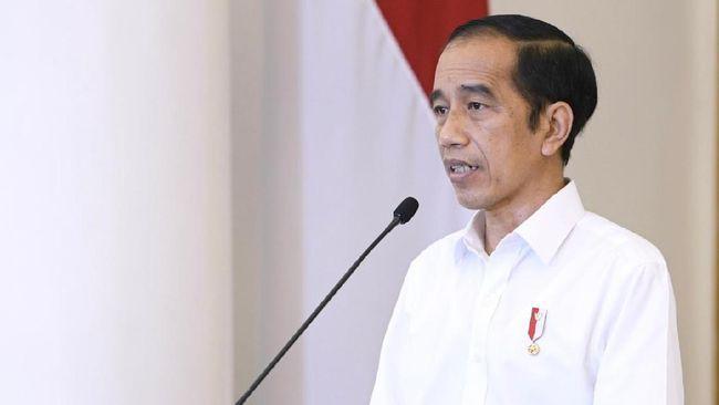 Jokowi menjelaskan Perppu Cipta Kerja menggunakan baju putih berdiri di podium